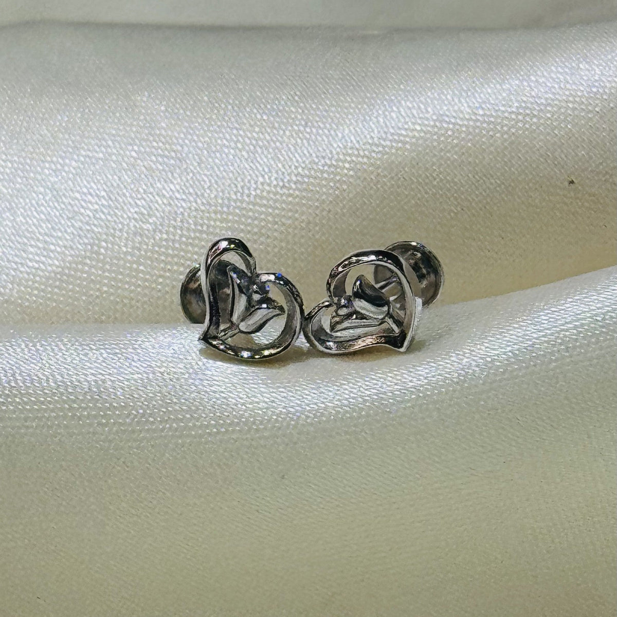 Open heart design 925 sterling silver stud earrings on ivory fabric